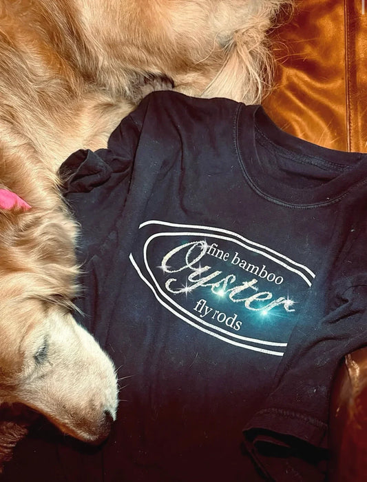 Oyster Fine Bamboo Fly Rods shirt in black with golden retriever dog resting on it.