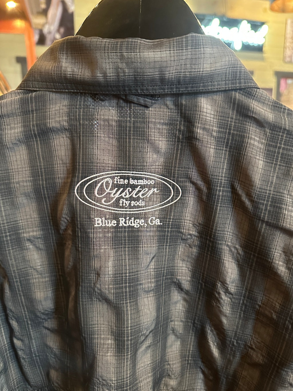 Simms Big Sky short sleeve fishing shirt in black plaid with Oyster fly rods logo.