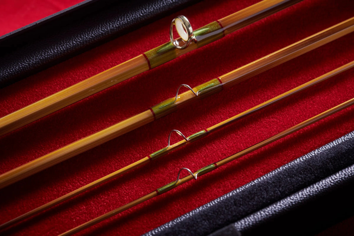 Close-up of bamboo fly rod with agate guide and green accents. 